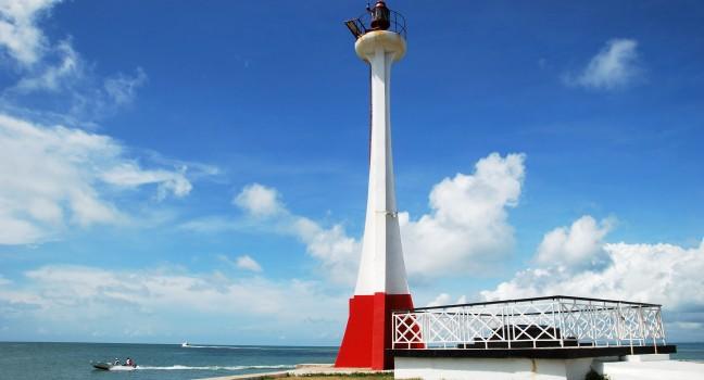 The lighthouse with boats passing by in Belize City (Belize).