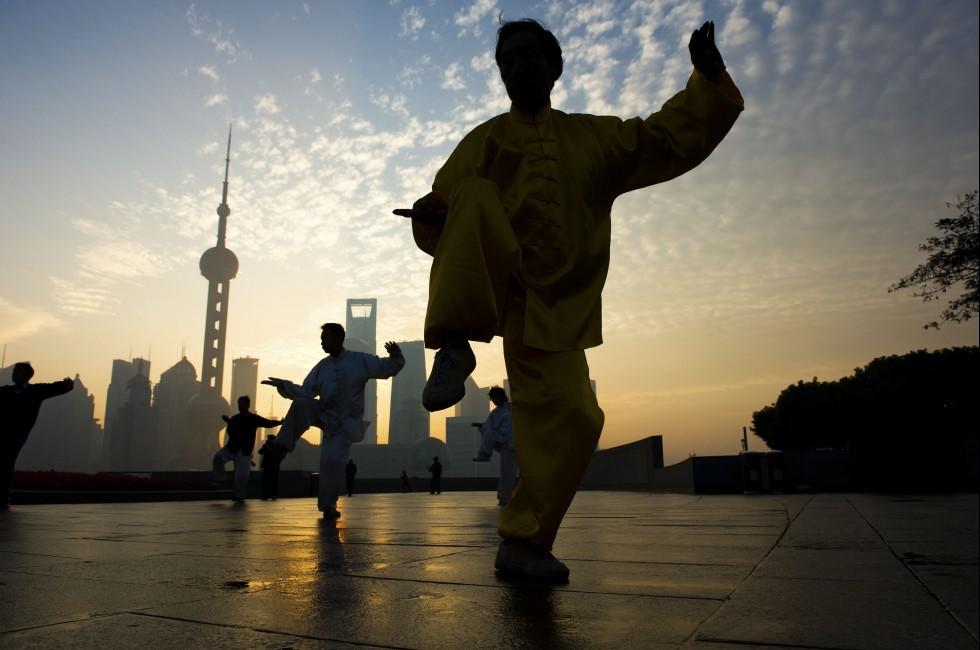 SHANGHAI - NOV 21:  People practice Taiji at the Bund, Oriental Pearl Tower in the background on November 21, 2010 in Shanghai, China.  The tower is one of the top ten Shanghai attractions.