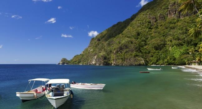 Boats on the clear waters of a beach in Soufriere in St Lucia;  