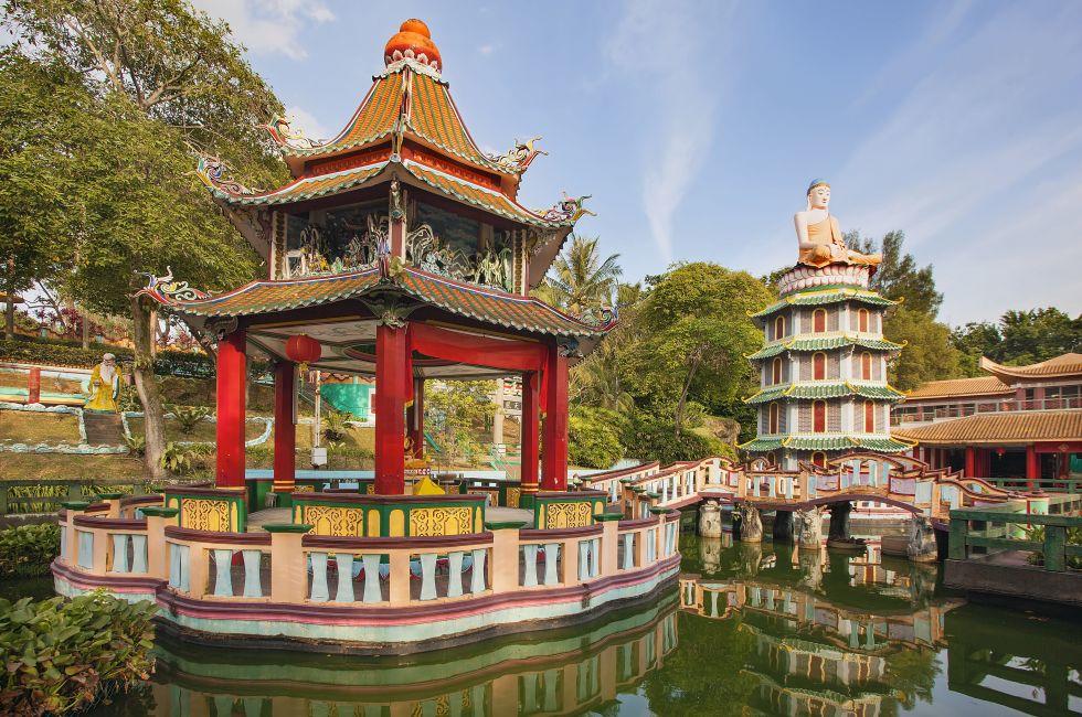 SINGAPORE - FEBRUARY 1, 2014: Chinese Pagoda and Pavilion by the Lake at Haw Par Villa Theme Park. This park has statues and dioramas scenes from Chinese mythology, folklore, legends, and history.; 