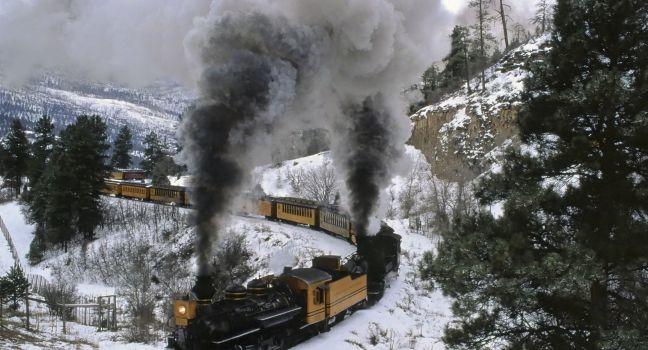 On a wintry curve of iron rails, coal-fired engines cough plumes of smoke and tug their locomotive burden across the Rocky Mountains, Train, Durango, Colorado