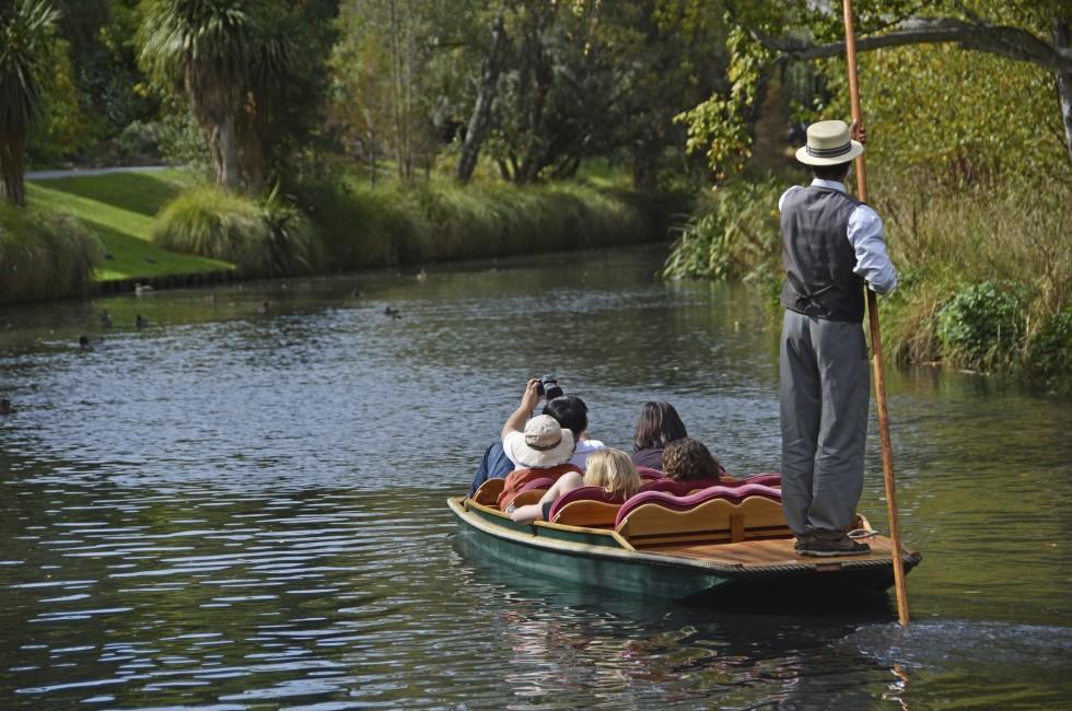 CHRISTCHURCH, NEW ZEALAND - MARCH 31, 2013: A boatman guides a group of tourists in their punt down the Avon River on Easter Sunday afternoon on March 31, 2013 in Christchurch.
