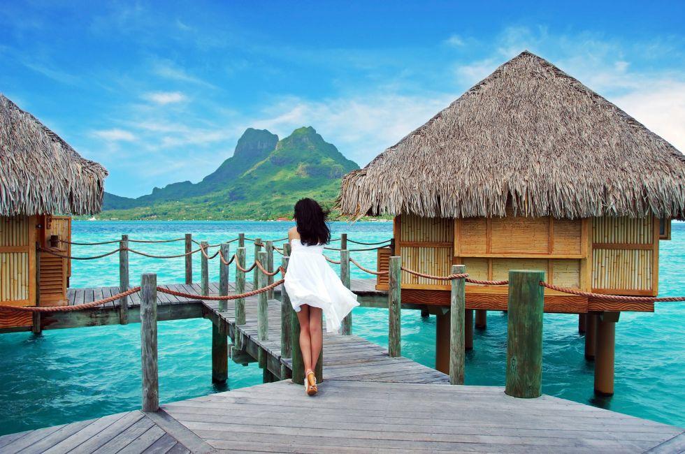 Young lady stand alone , look towards to the Otemanu mountain at Bora Bora island , French Polynesia , Pacific ocean .; 