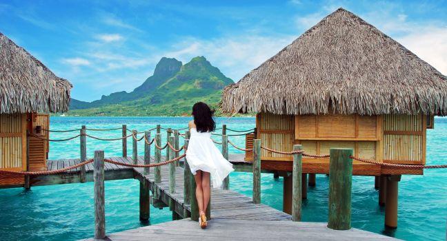 Young lady stand alone , look towards to the Otemanu mountain at Bora Bora island , French Polynesia , Pacific ocean .; 