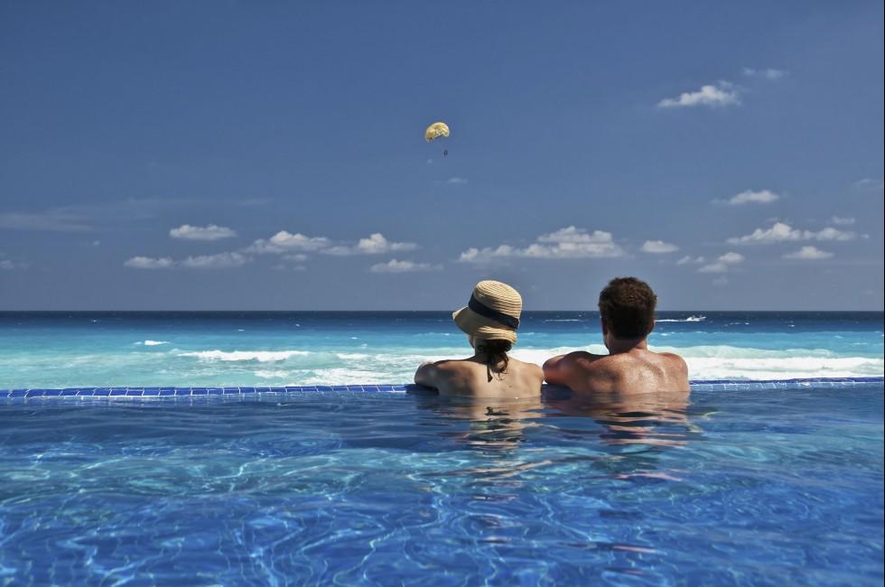 couple enjoying the view of the Caribbean from an infinity pool.