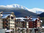 Ski lodges at Winter Park, Colorado with a view of the Rocky Mountains in the background.