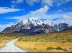 Windy day in early autumn in Patagonia. National Park Torres del Paine. Dirt road goes into the distance