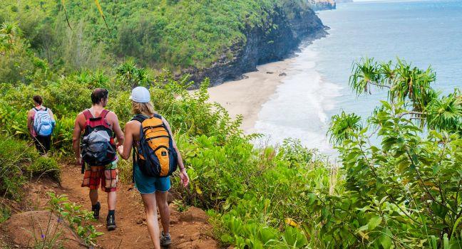 Hikers on the famous Kalalau Trail on the north shore of Kauai. The 11-mile trail that leads from Ke'e Beach to Kalalau Beach on the Na Pali coast.
