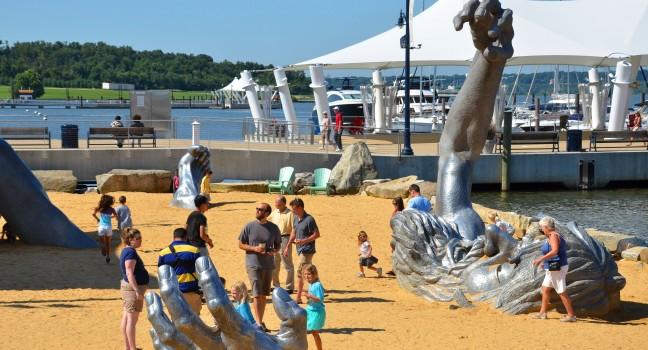OXON HILL, MD - AUGUST 24: Awakening Sculpture at National Harbor on August 24, 2013 at Oxon Hill, MD USA. A famous 70-foot statue of a giant embedded in the earth created by J. Seward Johnson Jr.