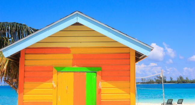 Bright yellow and orange wooden hut on the beach in the bahamas.