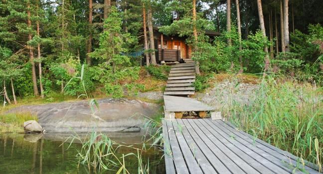 small forest lake with bridge in Lakelands region of Finland