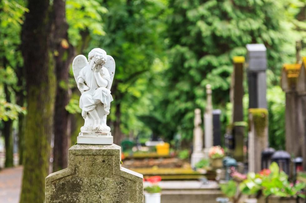 A white mourning porcelain angel on a cross in Mirogoj cemetery, Zagreb, Croatia.