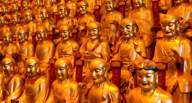 China, Shanghai city. Longhua Temple. Hundreds of golden buddhas sculptures having gathering inside temple.; 