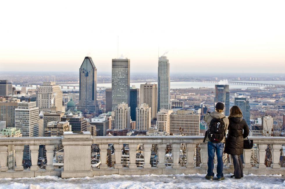 A couple looking toward downtown Montreal from Mont-Royal lookout in the winter.