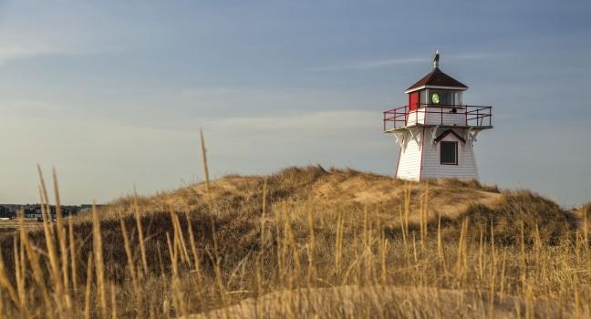 Lighthouse nestled in the sand dunes at Dalvay, in Cavendish National Park, on the north shore of Prince Edward Island, Canada.; 