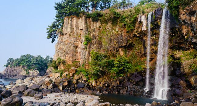 view of famous Jeongbang Waterfall on Jeju Island of South Korea; 
