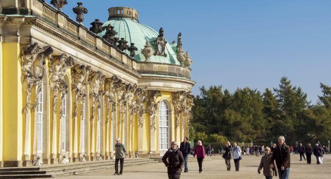 Unidentified people in front of Sanssouci Palace in Potsdam. Sanssouci Palace is former summer palace of Frederick the Great, King of Prussia, opened at 1747.