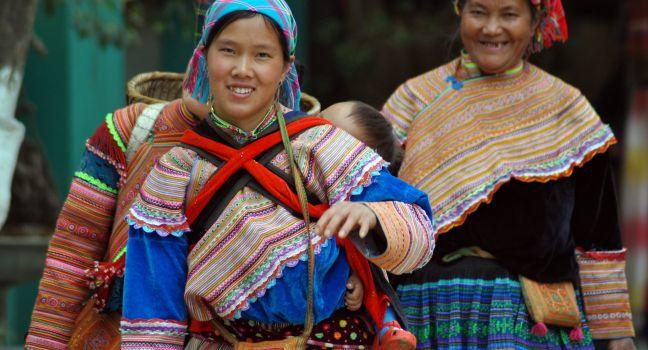 An unidentified Hmong tribe woman carrying her child in her backpack in Northern Vietnam. The Hmong people are one of the largest ethnic minorities in Vietnam.