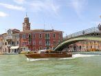 View of a canal with a bridge and a wooden boat on Murano, Venice, Italy. 