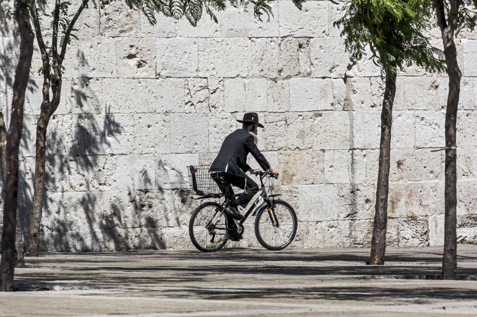 JERUSALEM, ISRAEL - MAY 26: Hassid rides a bicycle past the Jaffa Gate. The Western Wall is the most sacred sites in Judaism, it attracts thousands of devotees every day, on May 26, 2013 in Jerusalem; Shutterstock ID 142560175; Project/Title: Israel ebook
