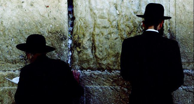 Facing eight-ton meleke limestone blocks that comprise the sacred Wailing Wall, a remnant of King David's First Temple, Chasidic Jews recite Amidah at heaven's gate.