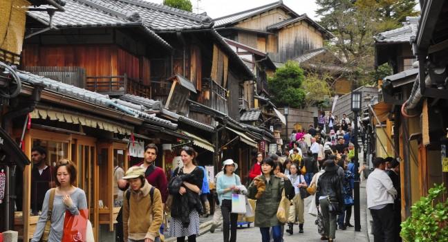KYOTO, JAPAN - APRIL 10 2012: Tourists wander a famous street, Sannen-Zaka, in Kyoto on April 10 2012.  The street is located in the heart of Kyoto attractions. Many souvenir shops can be found here.
